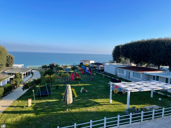 Giardino con giochi e vista sul mare.