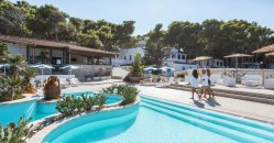 Vista aerea di un complesso su una scogliera, con piscina e mare circostante.