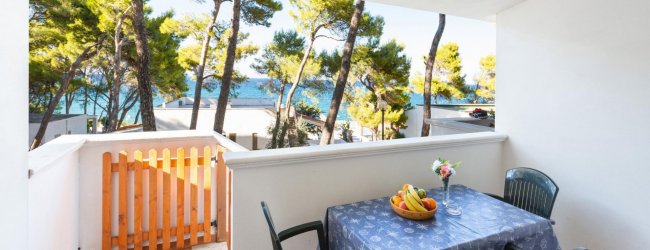 Terrazza con tavolo, sedie e vista mare.