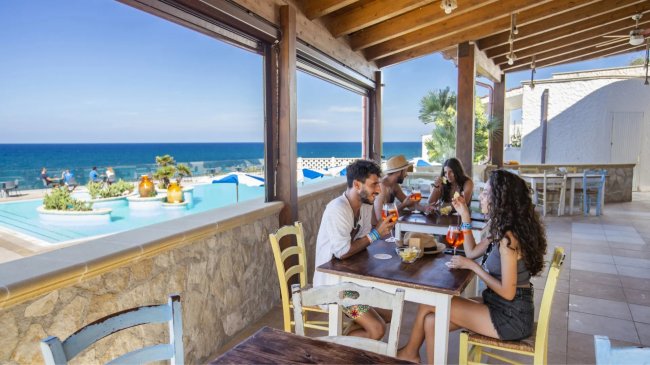 Persone sedute a un tavolo in un ristorante vista mare.