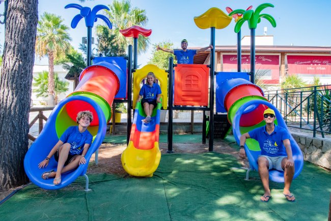 Bambini su scivoli colorati nel parco giochi.