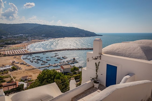 Vista su una baia con barche e spiaggia.