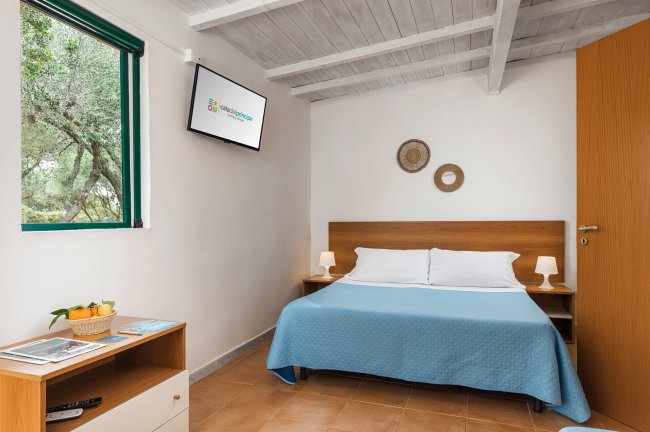 Camera con letto matrimoniale e finestra verde.