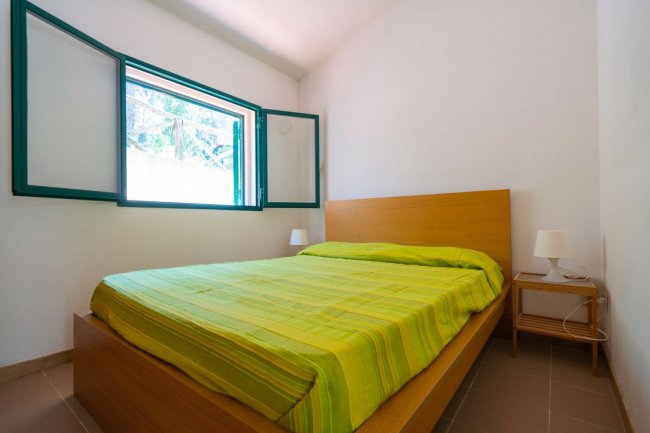 Camera con letto matrimoniale e lenzuola verdi.