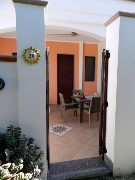 Cortile con tavolo e sedie, vista dall'ingresso.