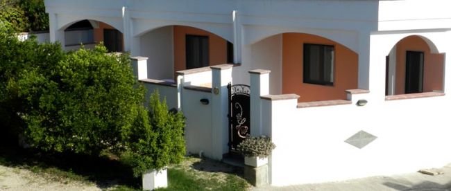 Facciata di una casa con portico e cancello nero.