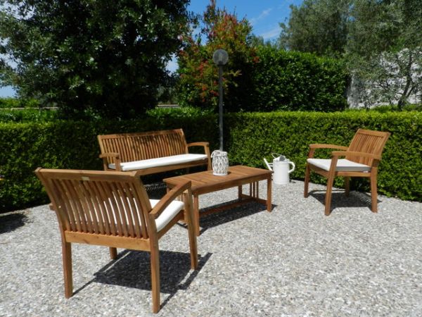 Arredo da giardino in legno su fondo ghiaioso.