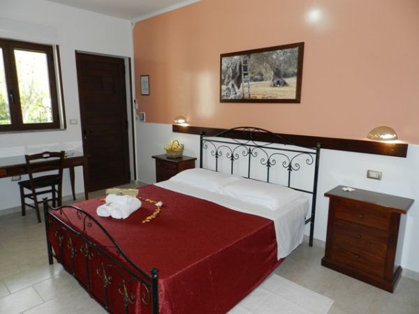 Camera con letto matrimoniale, pareti beige.