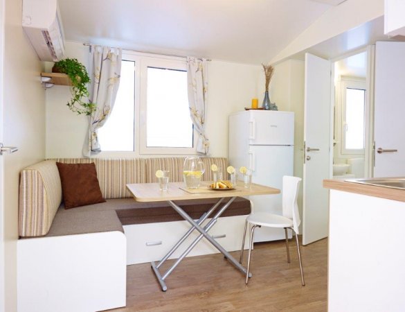 Cucina con tavolo pieghevole e sedie, frigo vicino.