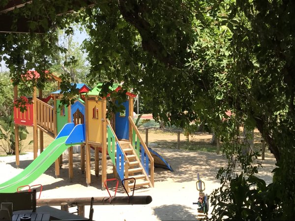 Parco giochi colorato con scivoli e sabbia.