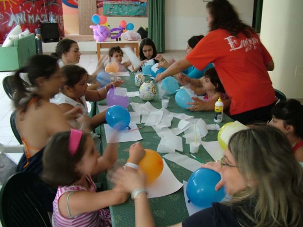 Bambini creano con palloncini e carta a un tavolo.