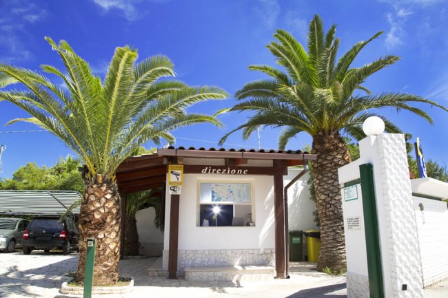 Ingresso con insegna e palme.
