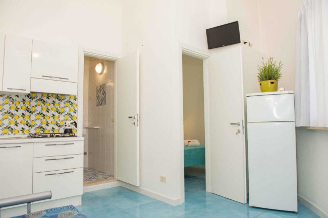 Cucina moderna con piastrelle colorate e porte aperte.