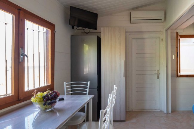 Cucina con tavolo bianco e frutta in ciotola.