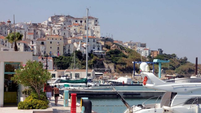 Porto con barche e case bianche su una collina.