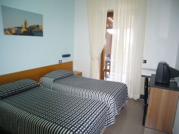 Camera con due letti singoli, copriletti a righe e una TV.