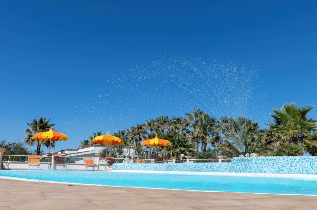 Piscina con ombrelloni arancioni.