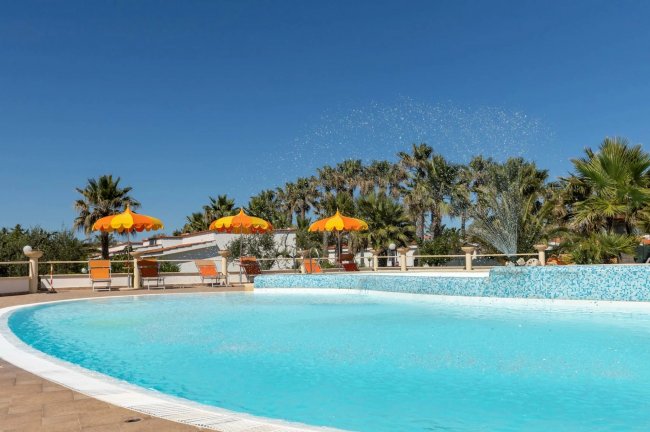 Piscina e fontane con palme.