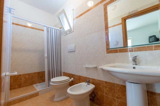 Bagno con doccia, bidet e specchio.