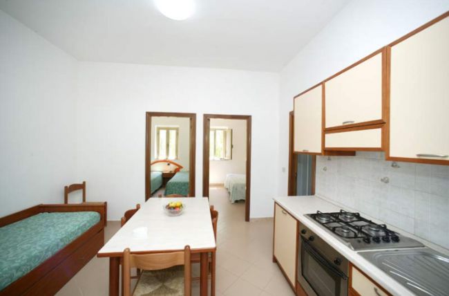 Cucina-soggiorno con tavolo e divano-letto.